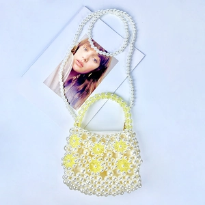 Detail of handmade pearl bead bag featuring yellow acrylic flower accents and silk lining