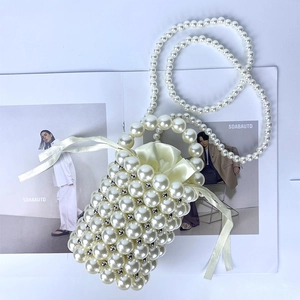 Detail of beaded pearl mini bucket bag with satin drawstring and woven pearl texture