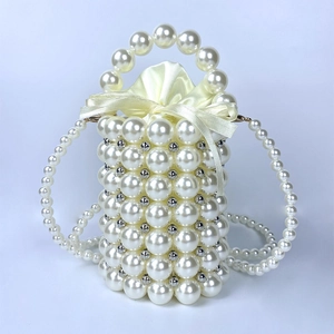 Close-up of handmade pearl bucket bag featuring bead weaving and satin drawstring