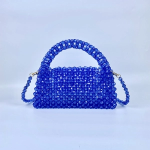 Blue hand-woven acrylic beaded pillow bag with top handle and crossbody strap