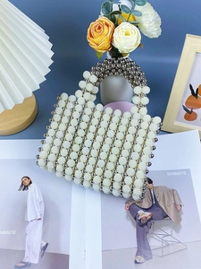 Elegant beaded handbag featuring white pearls and silver beads in a structured rectangular design
