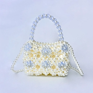 Detailed view of handmade pearl beaded handbag with light blue acrylic flower decorations