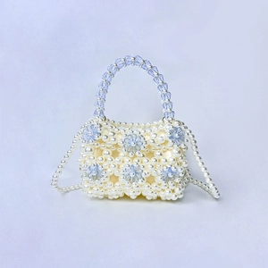 Detailed view of handmade pearl woven mini bag with blue crystal floral accents