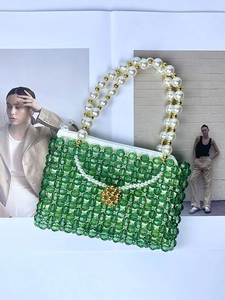Mini sac à main perlé vert fait main avec anse en perles sur fond de magazine