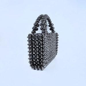 Detailed view of handmade metallic grey beaded handbag with sturdy woven structure