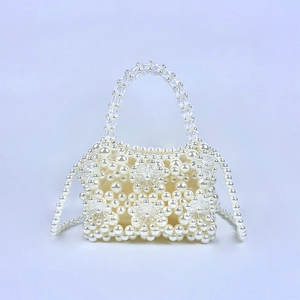 Detail of handmade pearl bead handbag featuring a 3D floral pattern and beaded handle