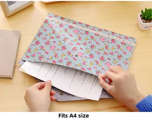Close-up of floral A4 file folder with lace edge and magnetic closure on wooden desk