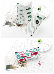 Detail view of canvas pencil cases with cactus and flamingo prints in a storage basket