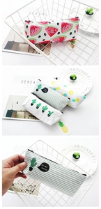 Close-up of canvas pencil pouches with fruit patterns and smooth zipper closures