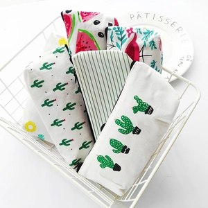 Minimalist canvas pencil cases with cactus and floral prints in a white metal basket