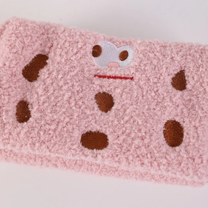 Close-up of pink plush pencil case featuring soft fleece texture and cute face embroidery