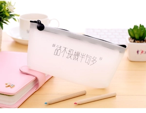 Detail of translucent frosted pencil case with black zipper on a wooden desktop