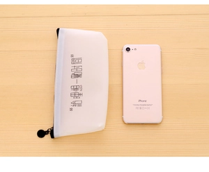 Translucent white pencil case with a black zipper next to a phone for scale comparison
