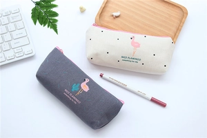 Close-up of flamingo canvas pencil cases in cream and grey colors on a tidy desk