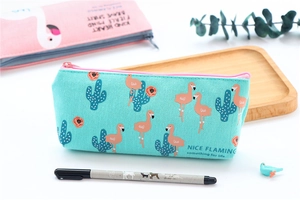 Close-up of mint green canvas pencil case featuring flamingo and cactus illustrations
