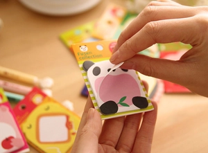Close-up of cute panda sticky notes being peeled showing paper texture and adhesive