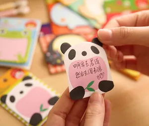 Close-up of cute panda sticky notes with round pink writing area on wooden background