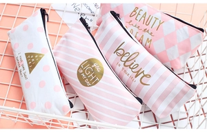 Detail of pink canvas pencil cases with stripes and dots in a white wire basket