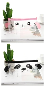 Cute transparent PVC pencil case with animal faces and colorful zippers on a magazine