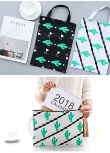 Detail of canvas document bag with cactus print and portable handle for office use