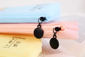 Détail d'une trousse en silicone macaron avec fermeture éclair ronde et imprimé d'été