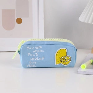 Detail of light blue canvas pencil case with lemon patch and large yellow zipper