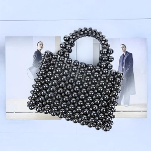 Macro detail of handmade silver beaded handbag on a stylish fashion magazine background