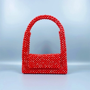 Nahaufnahme der roten Acryl-Perlenhandtasche mit gewebter Textur und Facetten