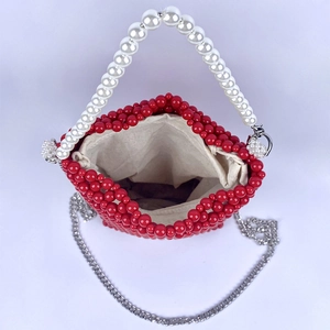 Macro detail of red beaded bucket bag with white pearl handle and silver chain strap