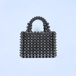 Detail of handcrafted dark grey pearl bead woven handbag with metallic luster finish