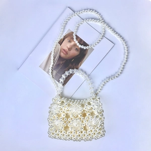 Detailed macro view of handmade acrylic pearl flower pattern on woven handbag strap