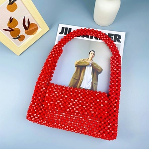 Draufsicht der roten Acrylperlen-Handtasche mit glänzender Textur auf dezentem Hintergrund