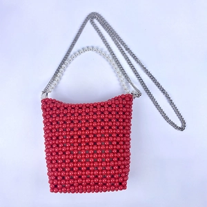 Detail of red beaded bucket bag with pearl handle and silver metal chain strap