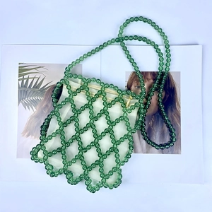 Dettaglio borsa a secchiello con perle verdi con pochette interna bianca e trama a rete
