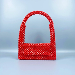 Detailansicht der roten Acryl-Perlenarbeit an der handgefertigten gewebten Tasche