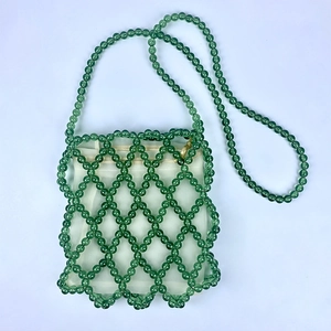 Dettaglio della borsa a secchiello in perline verdi fatta a mano con fodera in tessuto beige