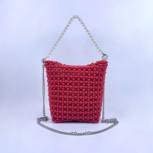 Detail of red beaded bucket bag with white pearl handle and silver metal chain strap