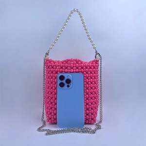 Detailed view of pink beaded bucket bag with white pearl handle and silver metal chain strap