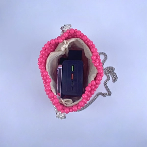 Internal view of pink beaded bucket bag showing storage space for phone and power bank