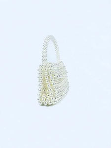 Detailed close-up of handmade white pearl beaded handbag with elegant rectangular shape