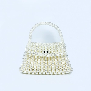 Detail of handcrafted white pearl beaded handbag with vintage French woven structure
