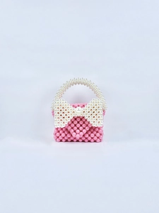 Dettaglio della mini borsa di perle rosa fatta a mano con fiocco di perle bianche