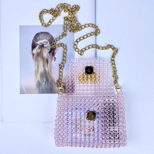 Detail of pink handmade beaded crossbody bag with gold magnetic clasp and metal chain