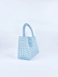 Detailed view of hand-woven light blue acrylic beaded square handbag with beaded handle