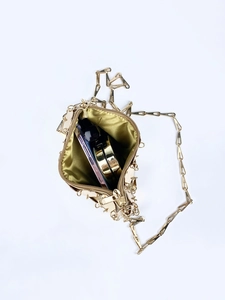 Dettaglio dell'interno della borsa a catena dorata con spazio per smartphone e cosmetici