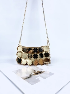 Dettaglio borsa di paillettes con dischi metallici dorati e sottile tracolla a catena