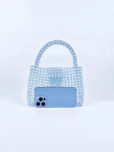 Detail showing handwoven light blue acrylic beaded handbag with mobile phone for scale