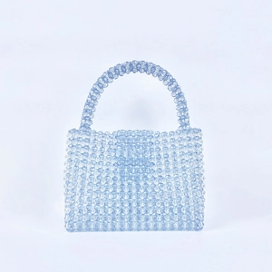 Detail of hand-woven light blue acrylic beads forming a grid texture on the handbag