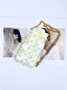 Detail of sequin woven mini bag with acrylic rings and gold chain shoulder strap