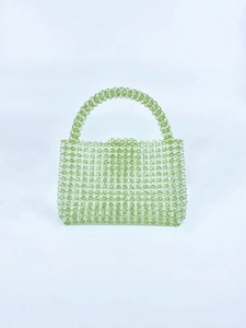 Macro detail of hand-woven light green and clear acrylic beads on a square handbag
